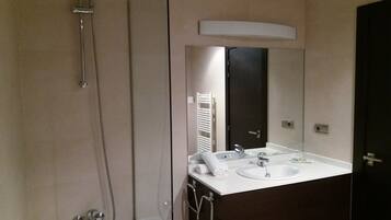 A modern bathroom with a bathtub, a shower, and a vanity with a mirror.