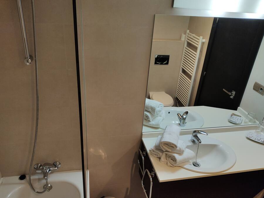 Un baño con bañera, lavabo y espejo.