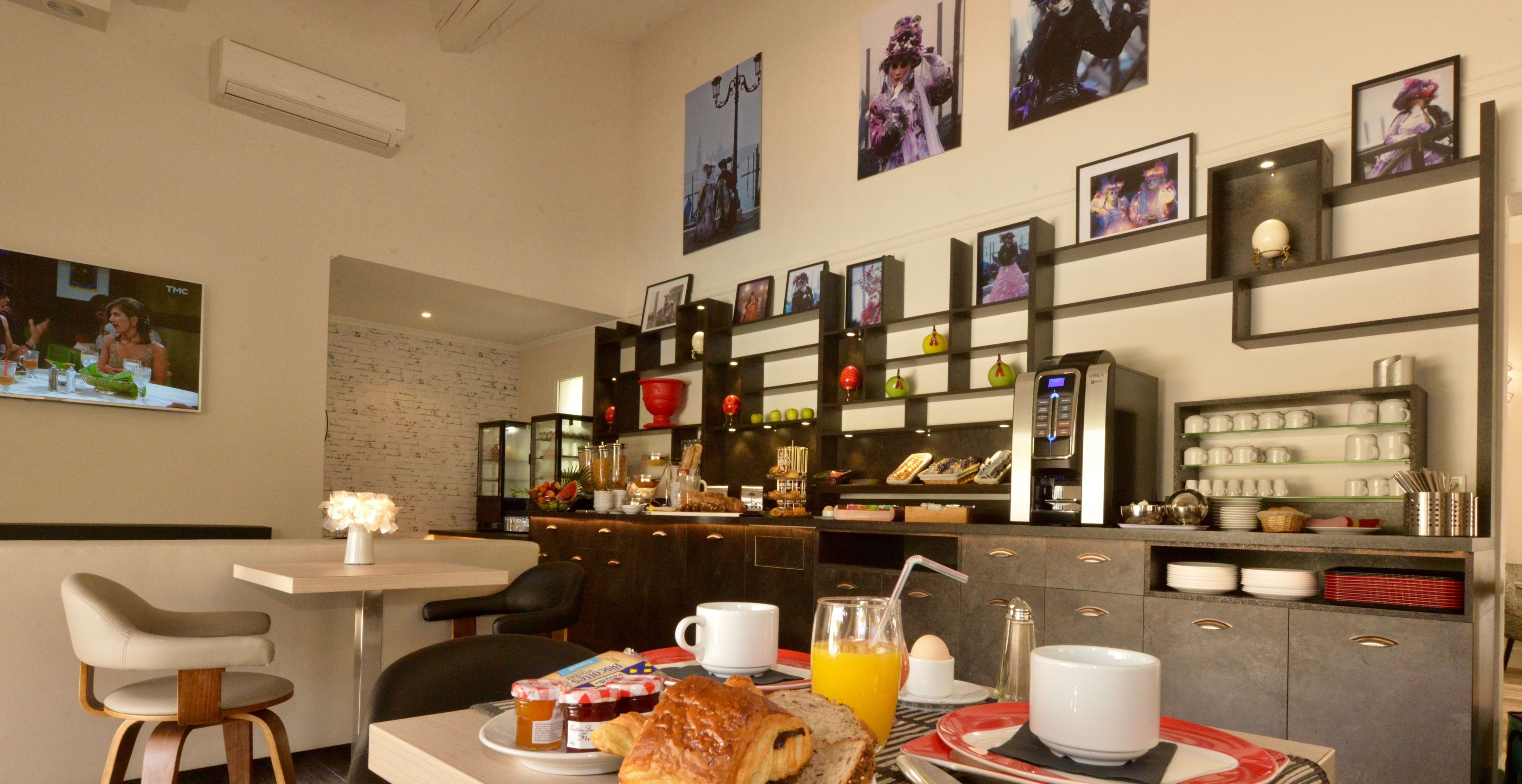 A breakfast setup with a table, chairs, and a counter with various items.