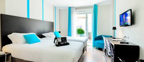 A modern hotel room with two beds, a desk, and a TV.