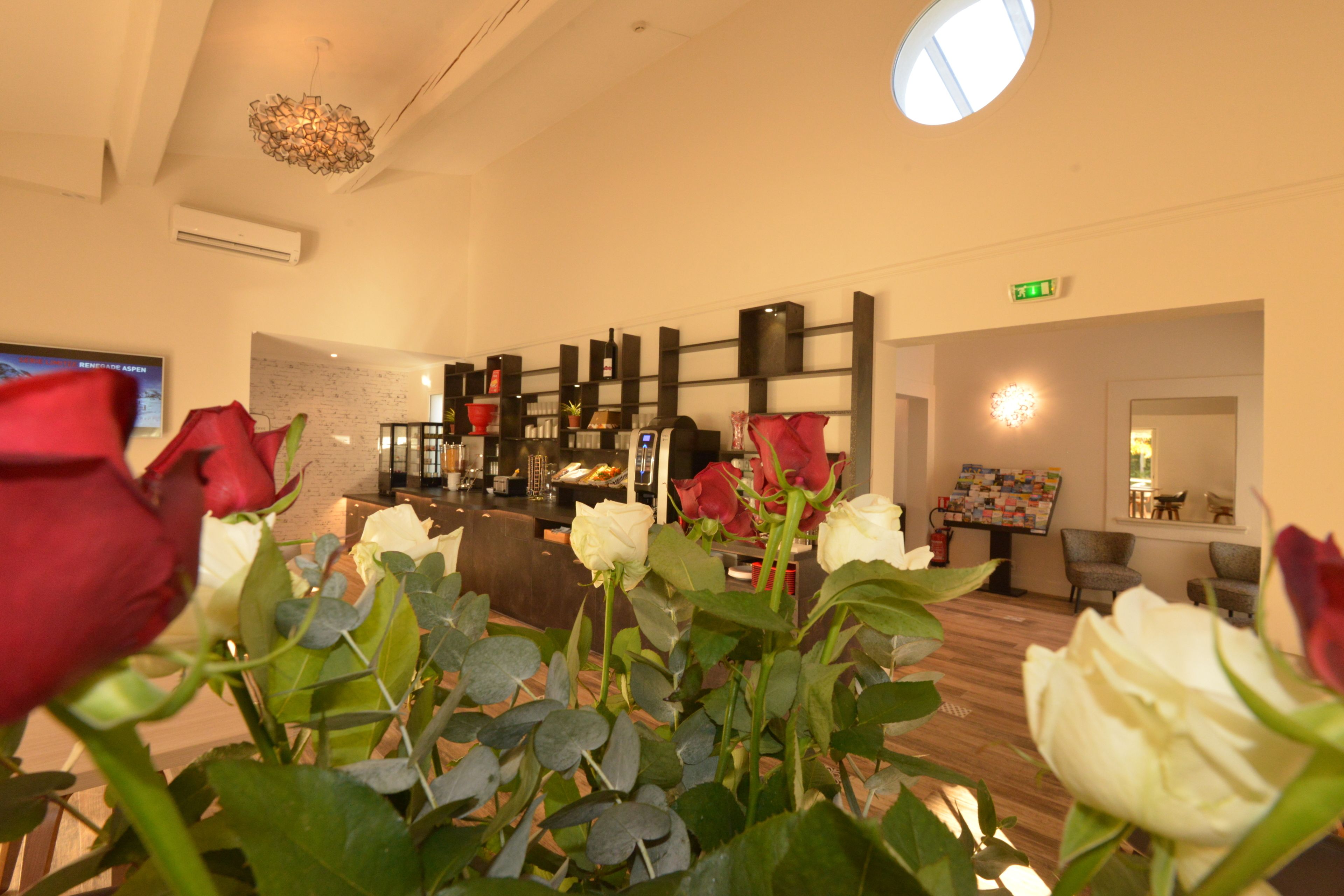 A hotel lobby with a reception desk, seating area, and a wall-mounted display.