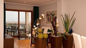 Un amplio salón con balcón, muebles modernos y plantas decorativas.