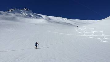 Une pente de montagne enneigée sous un ciel dégagé.