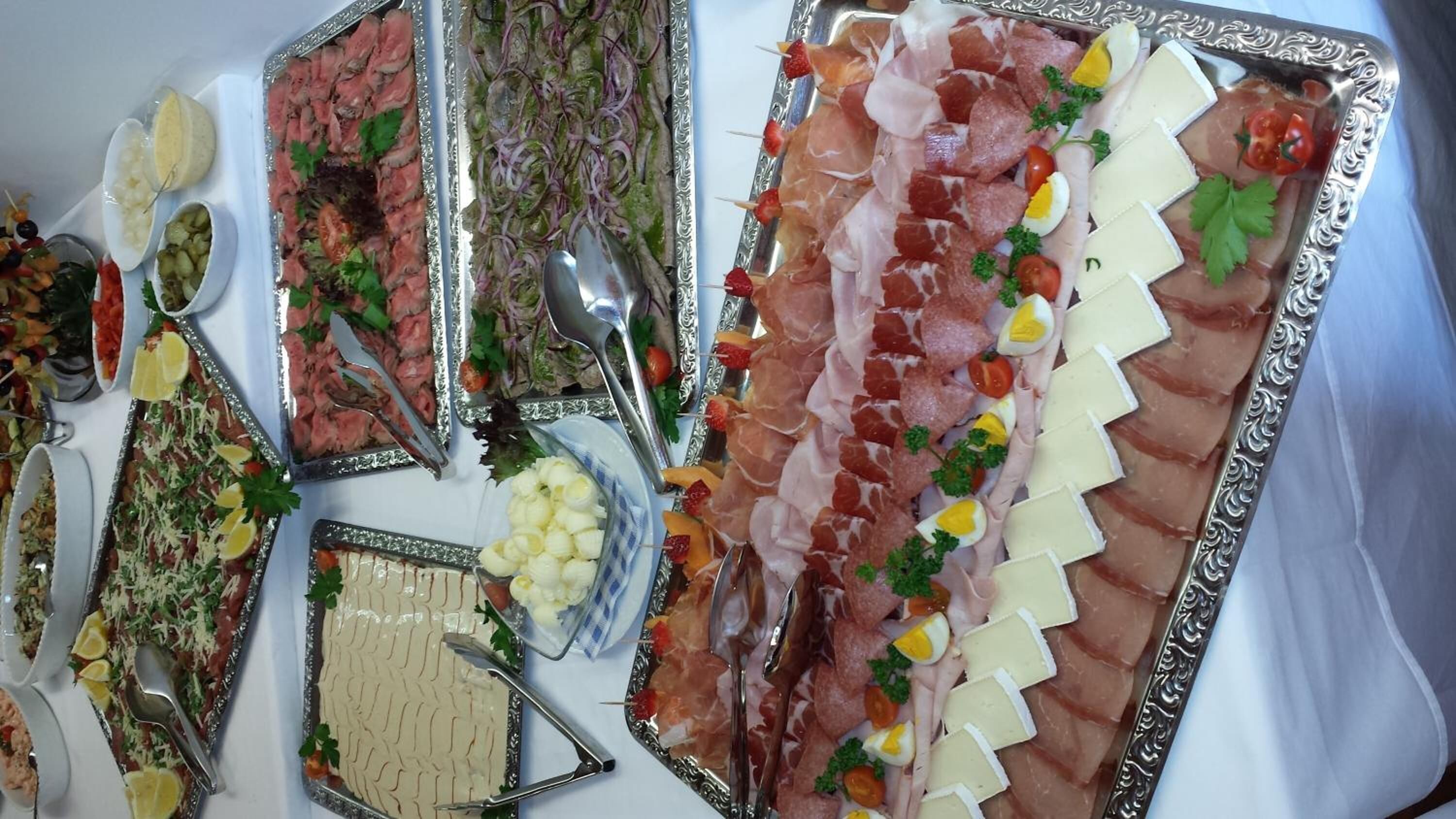 A table with various food items including meats, cheeses, and garnishes.