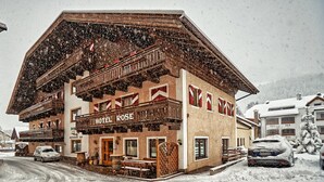 A hotel named "HOTEL ROSE" with a traditional alpine architectural style, featuring a wooden balcony and a signboard. - Hotel Rose (Villabassa)