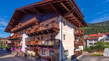 A multi-story hotel with wooden balconies and outdoor seating.