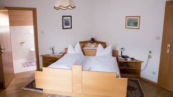 Ein Schlafzimmer mit einem Holzbett, Nachttischen, einer Lampe und einem Teppich.