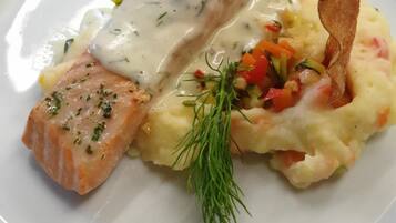 A plate with salmon, mashed potatoes, and a garnish of dill.