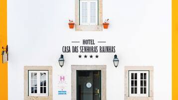 La façade d’un hôtel portant l’inscription « Hotel Casa das Senhoras Rainhas » et une enseigne indiquant qu’il s’agit d’un établissement quatre étoiles.