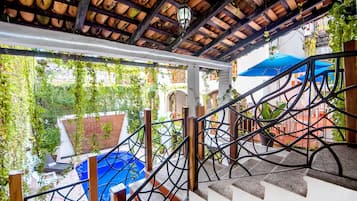 Alberca al aire libre, sombrillas en la alberca y camastros