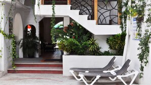 A modern building with a staircase, outdoor seating, and lush greenery. - Hotel Hacienda de Vallarta Centro (Puerto Vallarta)