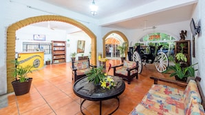 A spacious lobby with tiled flooring, wooden furniture, and potted plants. - Hotel Hacienda de Vallarta Centro (Puerto Vallarta)
