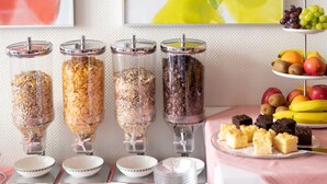 A buffet setup with various food dispensers and a fruit display. - Alte Post (Fulpmes)