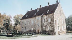 A large stone building with multiple windows and a prominent entrance.