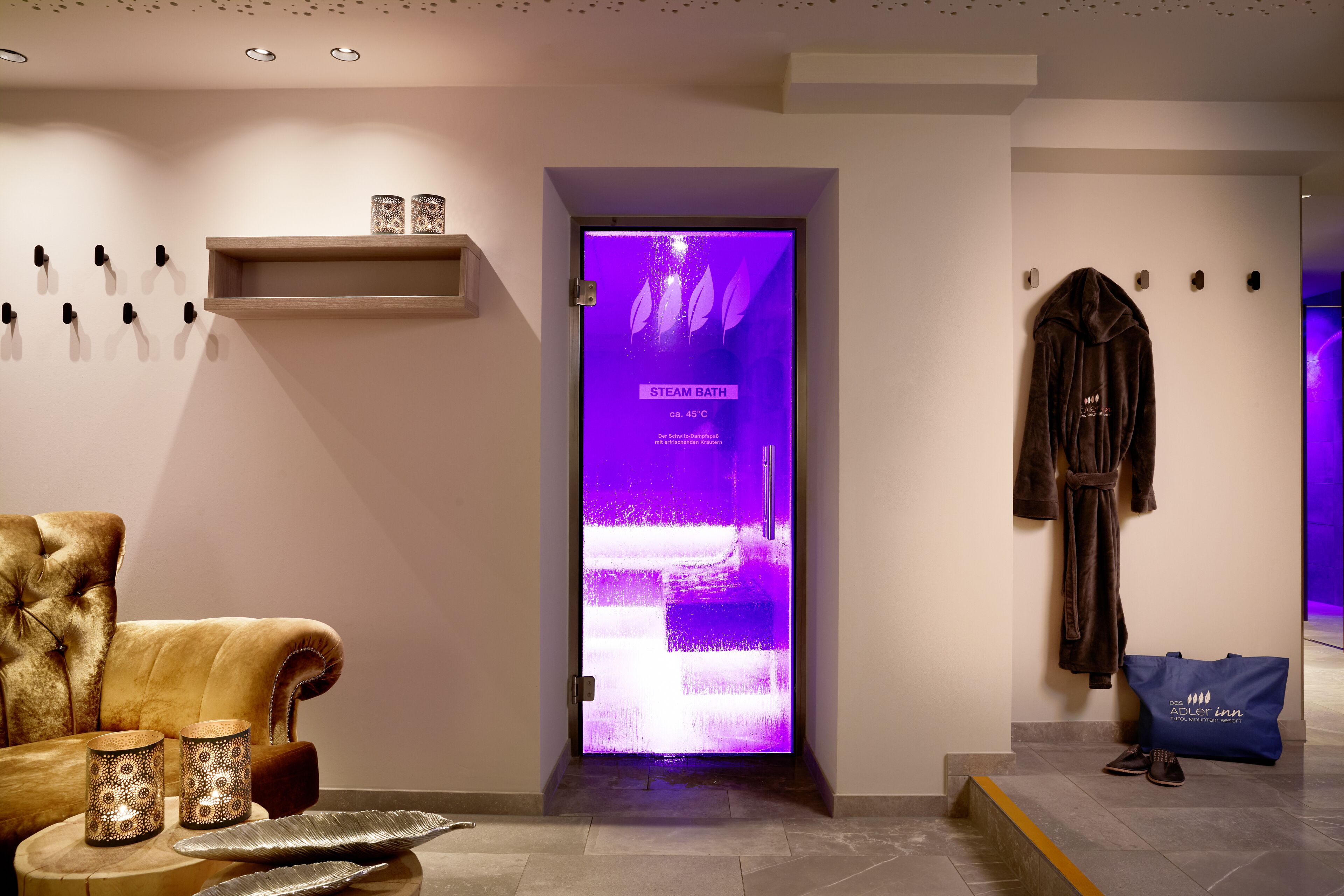 Un moderno vestíbulo de hotel con un letrero de baño de vapor, un sillón cómodo y un perchero para batas.