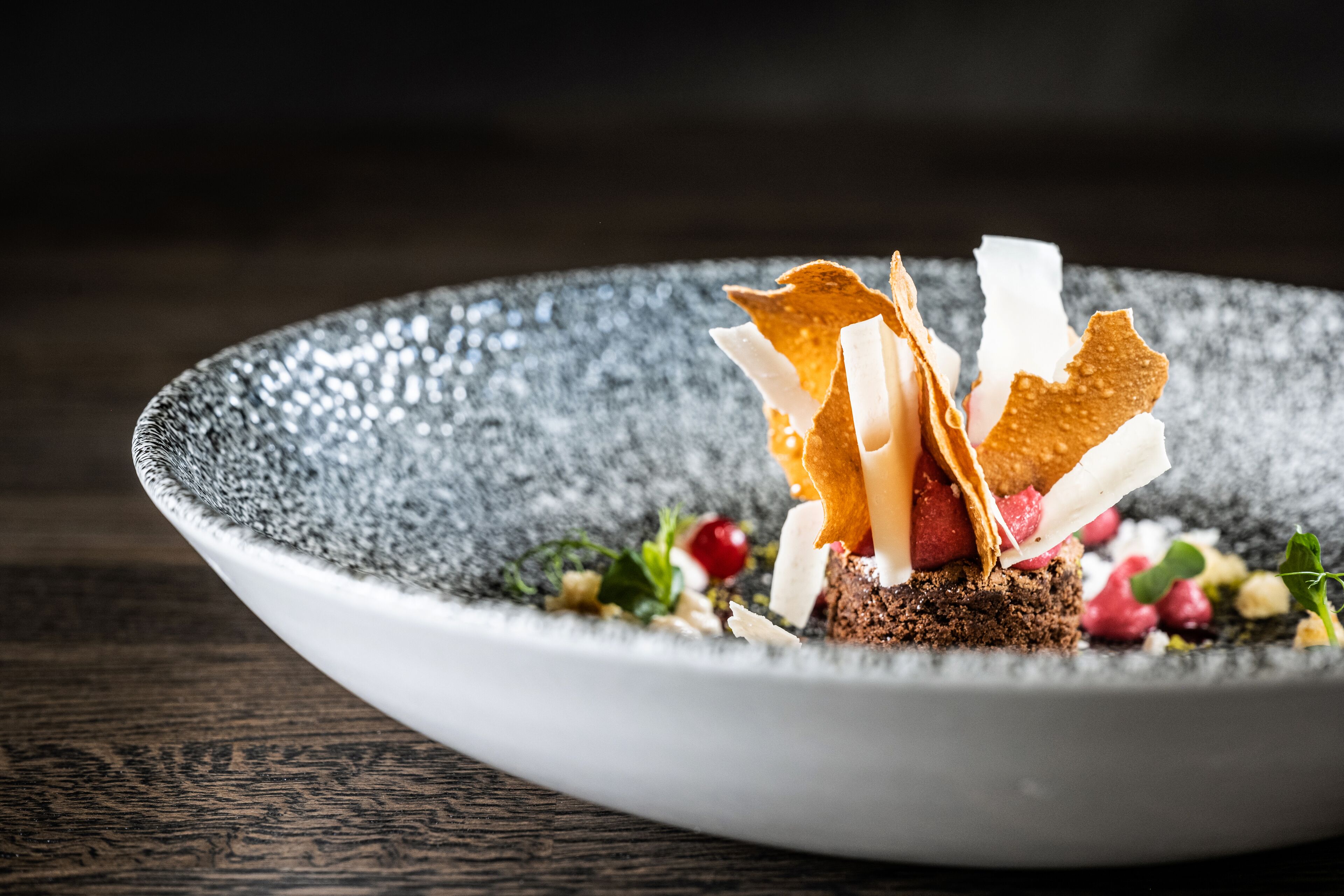 A dessert on a textured plate with a dark background.