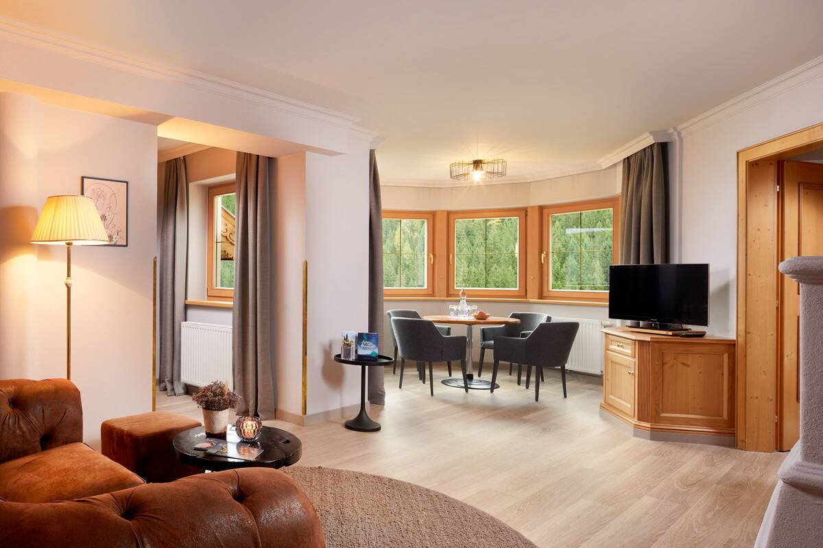 Una sala de estar moderna con un sofá, una mesa de centro, un televisor y un comedor con sillas y una mesa.