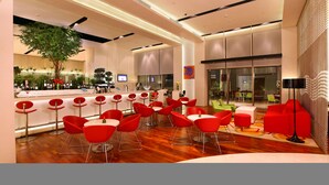 Un espace bar moderne avec des chaises rouges et un comptoir.
