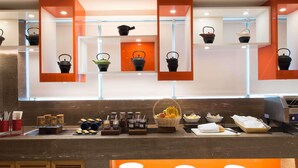 Un buffet proposant une variété de plats, des théières et un espace où les clients peuvent se servir eux-mêmes pour les boissons.