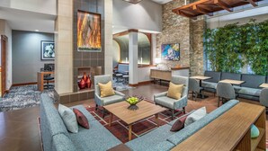 A modern lobby with seating areas, a reception desk, and a large plant wall. - Hyatt Place Riverside Downtown (Riverside)