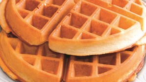 A close-up of a waffle with a golden-brown color and a grid pattern. - La Quinta Inn & Suites by Wyndham Tulsa - Catoosa Route 66 (Catoosa)