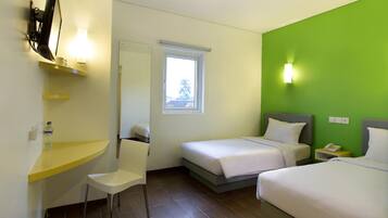 A hotel room with two beds, a desk with a chair, a TV, and a window.