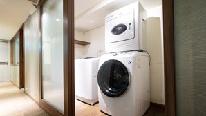 A laundry room with stacked washing machines and dryers, wooden flooring, and a glass partition. -  Hotel Cloud-ZhongShan  (Taipei)