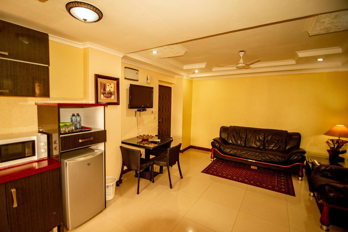 A compact living space with a kitchenette, dining area, and a sofa.
