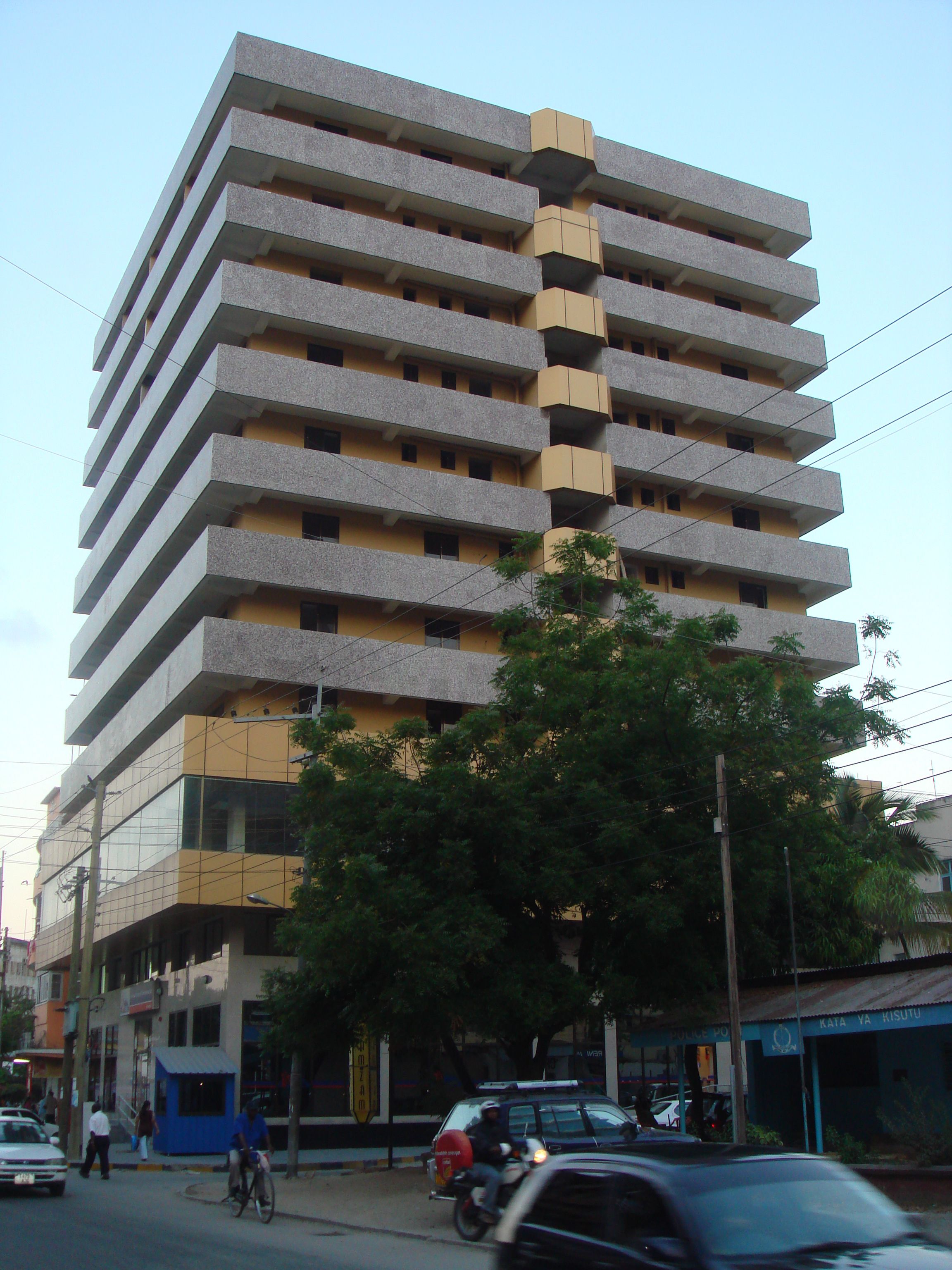 A multi-story building with a uniform facade, featuring balconies on each floor.