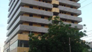 A multi-story building with a uniform facade, featuring balconies on each floor.