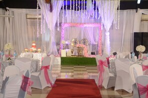 A wedding reception area with white chairs, a red carpet, and floral decorations. - Urban Rose Hotel and Apartment (Dar es Salaam)