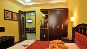 Una habitación de hotel con cama, armario, televisor y escritorio.