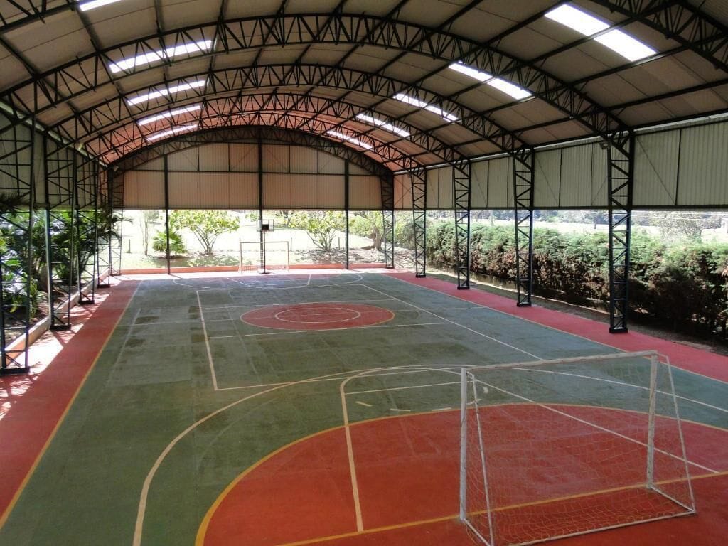 An indoor basketball court with a high ceiling and metal framework.