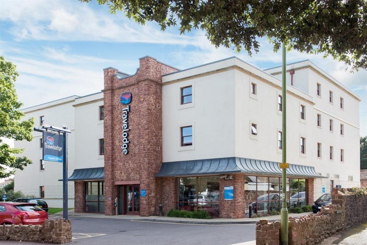 A Travelodge hotel with a brick facade, a covered entrance, and a parking lot.