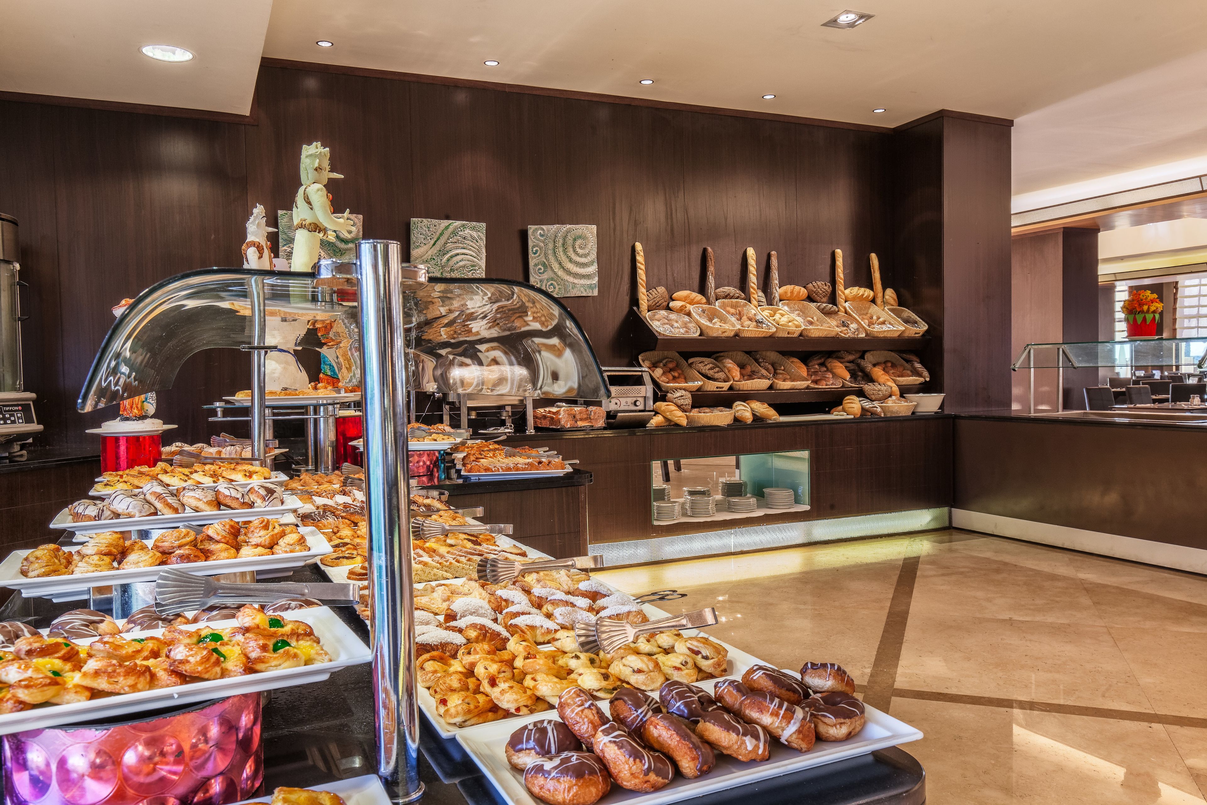 A buffet with various pastries and breads.
