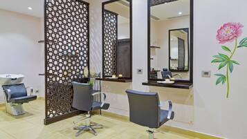 A salon with two chairs, a sink, and mirrors.