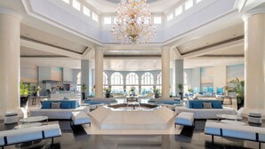 Een ruime lobby met een fontein in het midden, zithoeken en een bar.