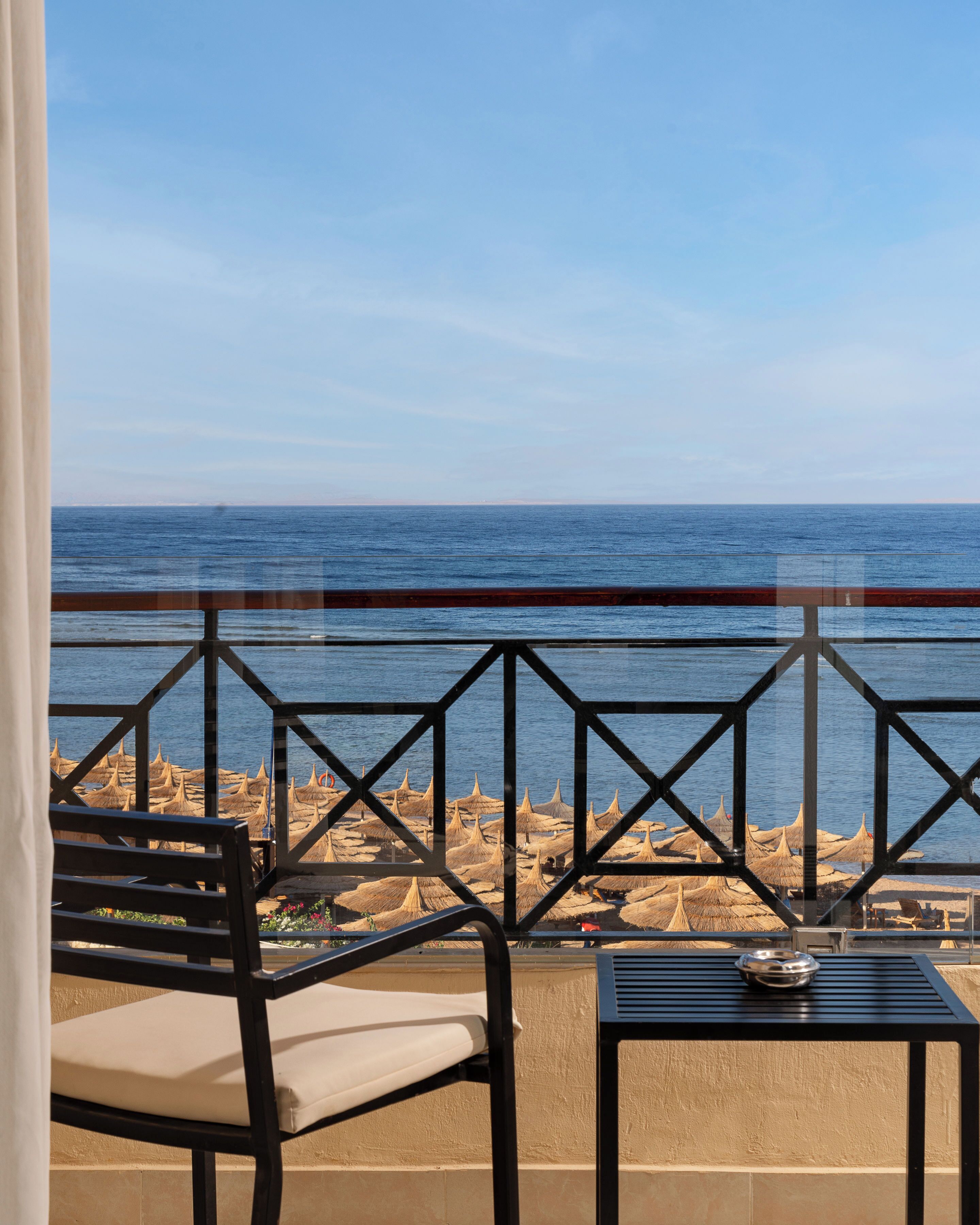 Ein Balkon mit Meerblick, einem Tisch und einem Stuhl.