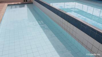 A swimming pool with tiled flooring and a tiled border.