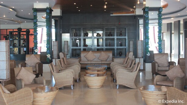 A spacious lobby with wicker furniture, a central sofa, and a display of vases. - Pamulinawen Hotel (San Nicolas)