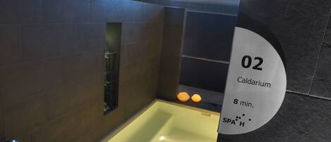 A spa area with a bathtub, a sign indicating '02 Caldarium, 8 min.', and a 'SPA H' symbol.