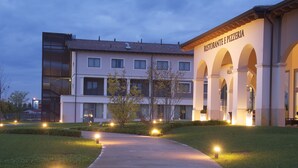 Een hotel met een modern gebouw en een restaurant genaamd "Ristorante e Pizzeria", met een bord waarop "Hotel Villa" staat.