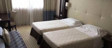 Una habitación de hotel con dos camas, un escritorio y un sofá.