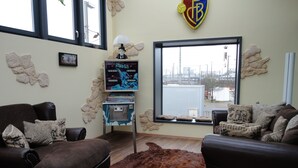 Un salon avec deux canapés, un tapis et un téléviseur fixé au mur.