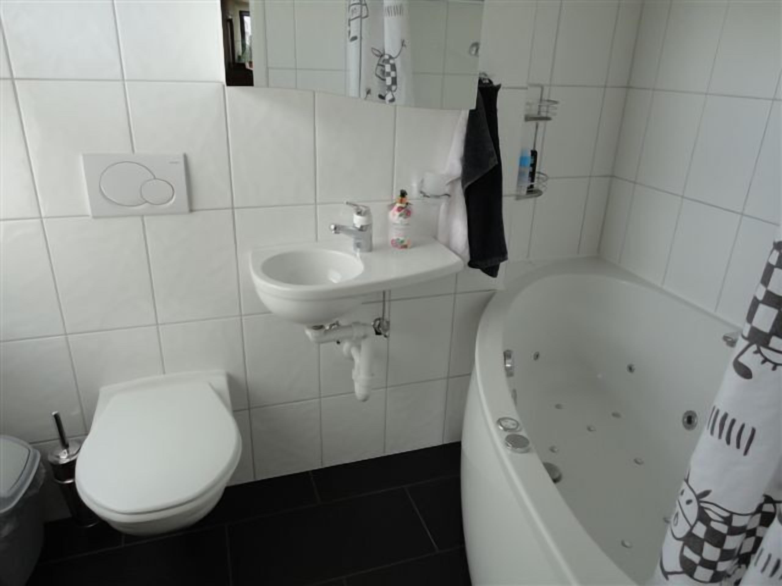 A bathroom with a toilet, sink, and bathtub.