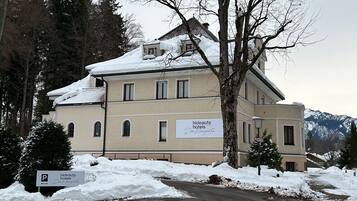 Experience the charm of Hideaus Hotels in a traditional two-story building with a symmetrical facade and multiple windows.