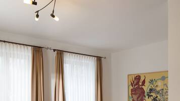 Una habitación de hotel con una cama, una silla, una mesa y un cuadro en la pared.
