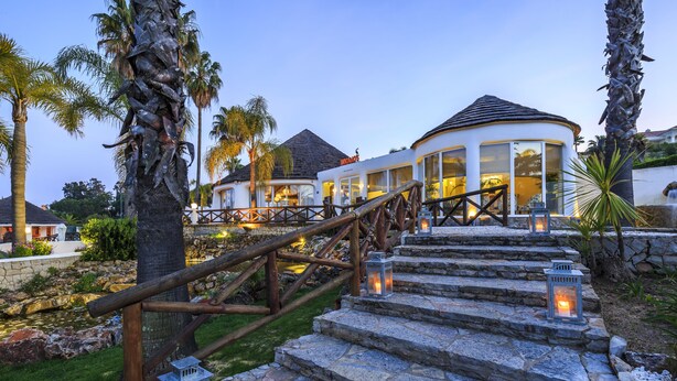 A stone staircase with lanterns, leading to a building with a dome roof and large windows. - Encosta do Lago (Loulé)
