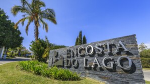 A sign for Encosta do Lago with a clear view of the surrounding greenery and palm trees. - Encosta do Lago (Loulé)