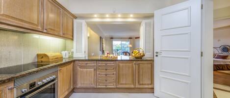 A kitchen with wooden cabinets, a built-in oven, and a white door.